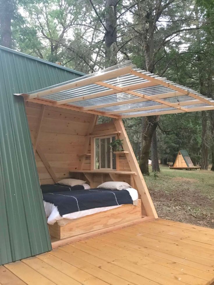 Cama de solteiro arrumada dentro de um mini chalé A-frame de madeira